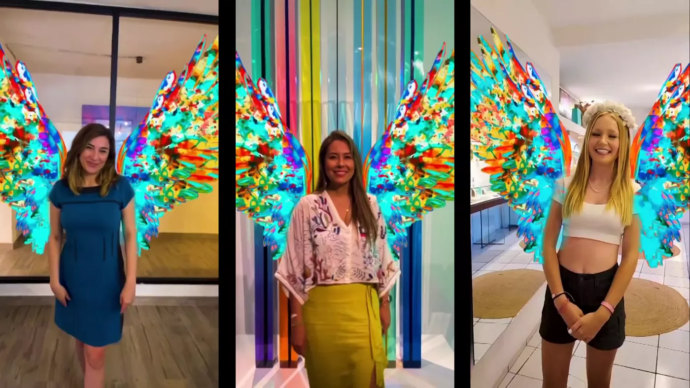 Three visitors with giant AR angel wings at The Cape